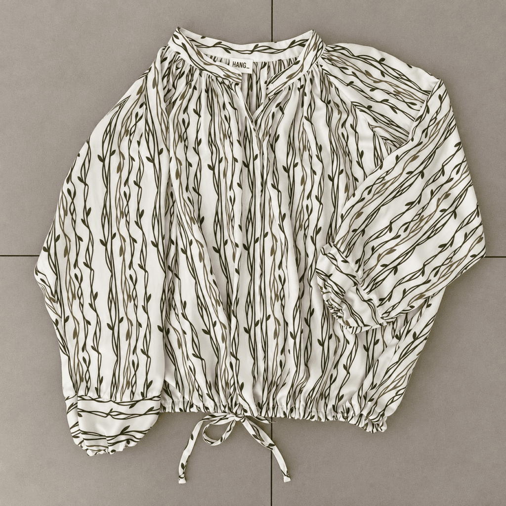 blusa floreale in chiffon su piastrelle neutre
