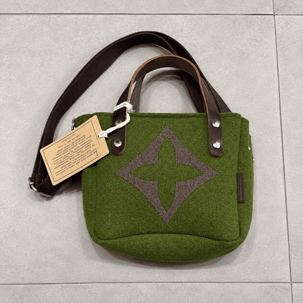 borsa verde in felt su piastrelle